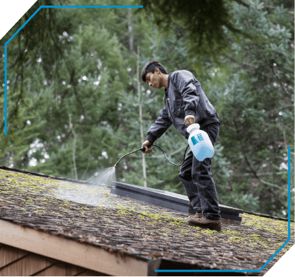 Man cleaning moss off roof